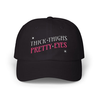Black cap with 'THICK THIGHS PRETTY EYES' text on a white background