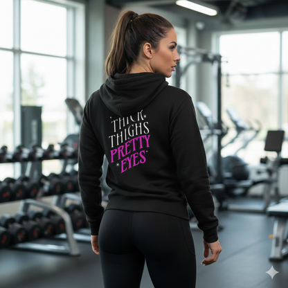 Woman wearing a black hoodie with text in a gym setting